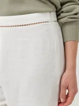 Pantalón blanco de lino orgánico y viscosa, de corte recto y tiro alto. Presenta calado en la cintura y en el ruedo.