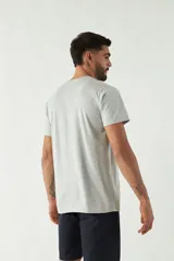 Remera gris de manga corta con cuello redondo y estampado con texto y gráficos en tonos azules.