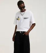 Pantalón negro de sarga, corte skater, con bolsillos grandes y recortes deslocados.