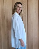 Camisa celeste de corte amplio, con cuello clásico y mangas largas.