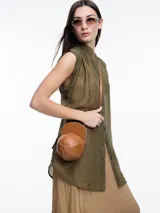 Camisa negra sin mangas con cuello mao y cierre frontal con botones.