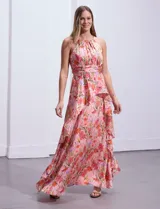 Vestido largo de gasa estampada con flores, escote halter, busto plisado, corte en la cintura con faja plisada, falda delantera con sobrecapa y abertura central en la espalda con cierre invisible.