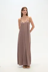 Vestido largo color marrón topo, de corte holgado, con escote en V y tirantes finos ajustables con argollas metálicas.