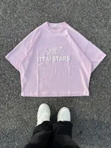 Remera celeste de corte holgado con cuello redondo y estampado en relieve con el logo de la marca y la frase "Ittai Stars".