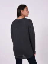 Blusa de tejido de punto color rosa viejo, con cuello redondo y mangas largas. Presenta apliques de strass en los hombros.