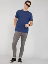 Remera azul de manga corta con cuello redondo y logo de Calvin Klein bordado en el pecho. Presenta una cinta distintiva en los hombros.