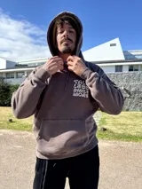 Canguro marrón con capucha y estampado blanco en la espalda con la frase "Talk Less Smile More".