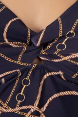 Tankini azul oscuro con estampado de cadenas y cuerdas doradas, con nudo en el frente, breteles anchos ajustables, espalda alta y tajos laterales.