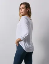 Blusa blanca de modal, marca Ruby Rd. Cuello a la base, escote en V bordado con flores. Manga ¾ amplia con puño fruncido.