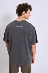 Remera gris oscuro de corte holgado con estampado pequeño en el pecho.