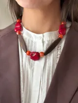 Collar corto con cuentas de resina rojas y naranjas, piedras rojas irregulares y cuentas de madera marrón.