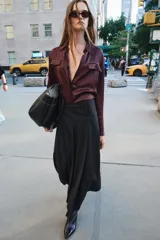 Falda midi negra de tiro medio confeccionada en hilatura con lana. Diseño con tablas y cierre con cremallera oculta en costura.