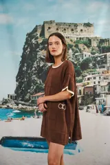 Vestido corto negro con patrón calado cuadrado, cuello redondo y mangas cortas con terminaciones a contratono en blanco.