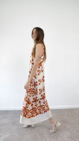 Vestido largo de seda estampada con flores amarillas sobre fondo blanco, corte halter.