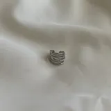 Anillo plateado con diseño ondulado de múltiples bandas entrelazadas.