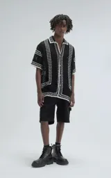 Camisa de manga corta tejida a crochet, color negro con detalles en blanco, de corte oversize.