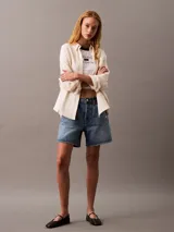 Camisa color crema de gasa doble, con cuello de punta, bolsillo de parche en el pecho, mangas largas con cierre de solapa enrollable y corte regular.