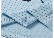 Remera estilo jersey de fútbol o americana, color celeste claro, con paneles de tela satinada y malla microperforada. Presenta cuello en V con ribete blanco, el número "90" grande en el frente con borde negro, y texto en la parte superior que dice "BAEN MADE" y "Madcapsclub".