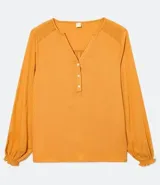 Blusa color mostaza de manga larga abullonada, con escote en V y botones en el frente.