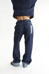 Pantalón de jean azul oscuro, de corte baggy y tiro bajo, con pespuntes a contratono color verde lima y logo bordado en el bolsillo trasero. Confeccionado en denim 100% algodón.