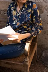 Camisa azul marino con estampado floral en tonos naranja, amarillo y blanco, de corte clásico y manga larga.