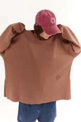 Gorra marrón de algodón con visera curva y bordado frontal con la palabra "HAHA" repetida en círculo.