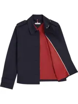 Gabardina corta azul marino de Tommy Hilfiger, con botonadura simple, cuello inglés, trabillas en los hombros, solapa de protección delantera y trasera, puños con tira y botón, y logo metálico en el puño.