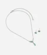 Conjunto de collar con cadena plateada y dije con tres zirconias ovaladas color aguamarina y aros tipo botón con zirconias aguamarina.