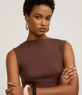 Vestido midi de tejido rib color marrón, con escote canoa y manga corta. Presenta un corte recto que entalla la silueta, confeccionado en una mezcla de algodón y elastano para mayor comodidad y flexibilidad.