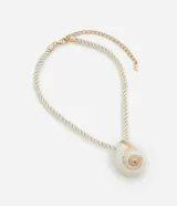 Collar corto con cordón torcido color crema y colgante grande de caracola con detalles dorados.