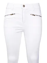 Pantalón de jeans blanco, corte skinny, tiro medio, con bolsillos delanteros con cierre metálico color bronce y ruedo desflecado.