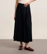 Falda midi evasé de sastrería color negro, con efecto plegado.