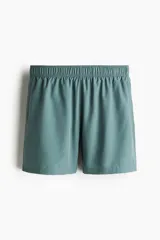 Short deportivo a media pierna en tejido funcional DryMove™ color verde azulado, con cintura elástica y cordón de ajuste oculto. Incluye bolsillos laterales y suspensor interior de malla.