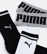 Kit de tres pares de medias deportivas Puma de caña larga. Un par color beige con dos rayas marrones horizontales en la parte superior y logo marrón en el tobillo. Un par color crema liso con logo blanco en el tobillo. Un par color marrón con una raya blanca horizontal en la parte superior y logo blanco en el tobillo.