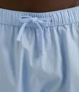 Pijama americano celeste, compuesto por camisa de manga corta con cuello solapa y botones frontales, y bermuda con cintura elástica.