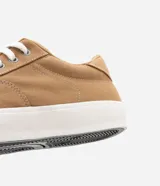 Championes urbanos de caña baja, color beige, con recortes y costuras contrastantes en blanco. Cierre con cordones y puntera redonda.