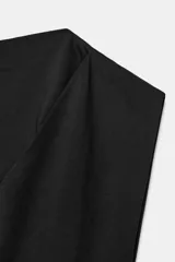 Top de algodón color beige, con cuello recto, mangas asimétricas y detalle de tejido drapeado en el lateral.