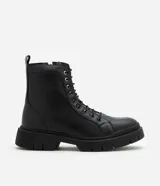 Bota de caña media color negro, estilo coturno, con cordones y cierre lateral. Suela track.