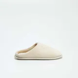 Pantuflas cerradas color beige con interior de felpa.