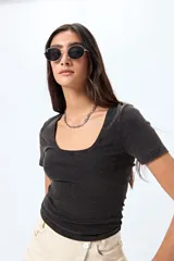 Remera color beige de punto acanalado, con escote redondo amplio y mangas cortas.