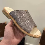 Sandalias tipo chata color gris con estampado de cocodrilo, confeccionadas en cuero vacuno.