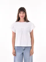 Remera blanca de manga corta con cuello redondo y detalle de bordado inglés en el canesú y los bordes de las mangas.