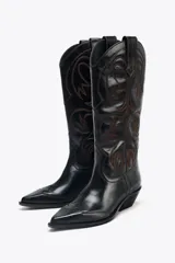 Bota de cuero negra estilo cowboy con bordados marrones, caña ancha, doble tirador y tacón medio.