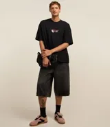 Remera negra de corte oversized con estampa en la espalda con la frase "Heart Eyes Only" y un oso cupido.