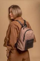 Mochila urbana color gris con detalles en cuero sintético negro. Cuenta con un compartimento principal amplio y un bolsillo frontal con cierre.