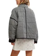 Chaqueta acolchada con estampado floral en tonos rosa y verde sobre fondo negro. Tiene cuello camisero, cierre frontal abierto, bolsillos de parche y ribete negro en contraste.
