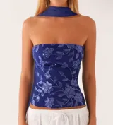 Top strapless azul con estampado floral y detalle de pañuelo al cuello.