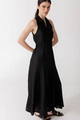 Vestido midi negro con cuello camisero, sin mangas y cierre frontal con cremallera.