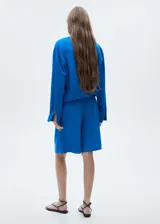 Short azul eléctrico de lyocell y lino con diseño wideleg, trabillas, cierre delantero de botón, gancho y cremallera, detalle de pinzas y tiro alto.