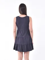 Vestido corto gris oscuro con escote en V, sin mangas, corte imperio y falda escalonada con botones decorativos.